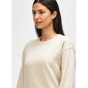 A light beige Gildan Heavy Blend adult crewneck sweatshirt with a relaxed fit and a logo.