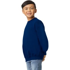 A youth sweatshirt in navy blue, featuring a simple design and long sleeves, worn by a smiling child.