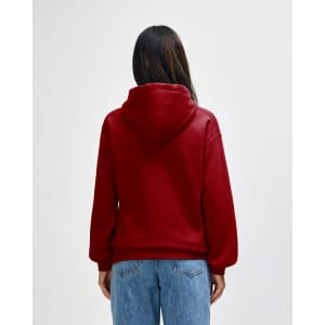 A red hooded sweatshirt displayed from the back, featuring a large hood and a relaxed fit. The image includes a branding logo.
