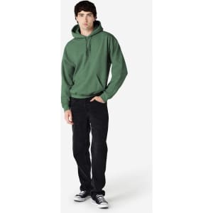 A green hooded sweatshirt worn by a model, paired with black jeans and sneakers, featuring a logo.