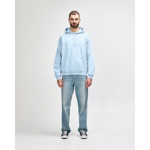 A light blue Gildan Heavy Blend adult hooded sweatshirt paired with denim jeans and white sneakers.
