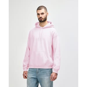 A man wearing a pink Gildan Heavy Blend adult hooded sweatshirt with a front pocket and hood.