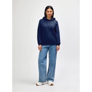 A navy blue Gildan Heavy Blend adult hooded sweatshirt worn by a model with jeans and sneakers. The sweatshirt features a hood and pockets.