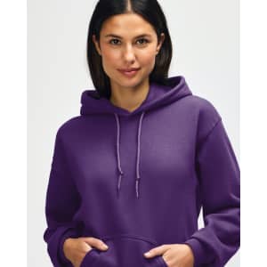 A purple hooded sweatshirt is being worn by a young man, who is pulling the hood over his head.