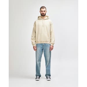 A light beige hooded sweatshirt worn with blue jeans, featuring a front pocket and a drawstring hood.
