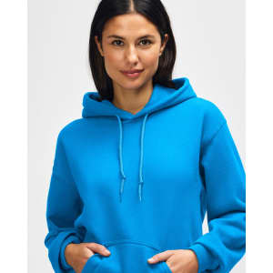 A blue Gildan Heavy Blend adult hooded sweatshirt worn by a female model, featuring a hood and drawstring.