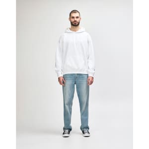 A white hooded sweatshirt worn by a young man, paired with black jeans and sneakers. The sweatshirt features a logo.