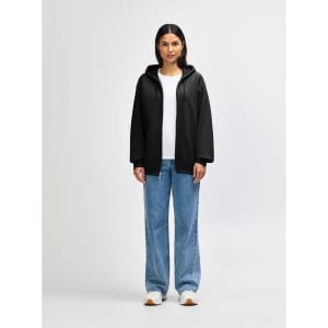 A model wearing a black Gildan Heavy Blend Adult Full Zip Hooded Sweatshirt, paired with black pants and sneakers.