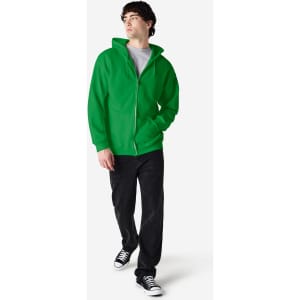 A man wearing a green Gildan Heavy Blend full zip hooded sweatshirt, paired with jeans and sneakers.