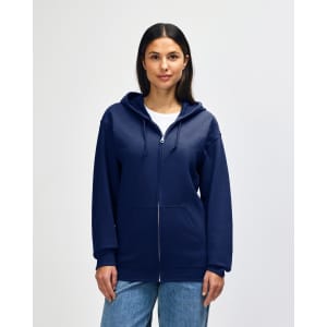 A navy blue Gildan Heavy Blend adult full zip hooded sweatshirt on a model adjusting the hood. The sweatshirt has a logo.