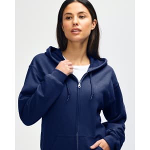 A model is wearing a navy blue Gildan Heavy Blend adult full zip hooded sweatshirt with black pants and sneakers.