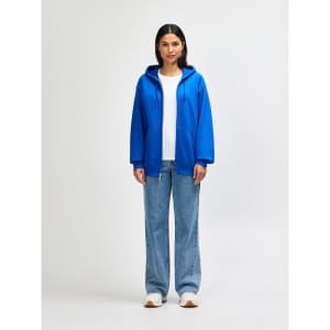 A blue Gildan Heavy Blend adult full zip hooded sweatshirt on a model, paired with light jeans and white shoes.
