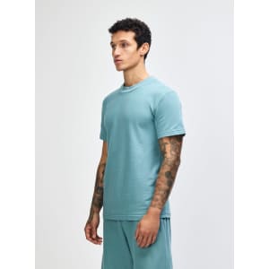 A unisex pique mockneck t-shirt in a teal colour, featuring a slight side profile view. The shirt has a logo.