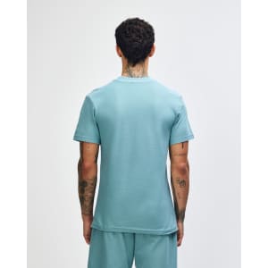 A green mockneck unisex T-shirt featuring a back view of the garment. It has a logo.