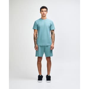 A unisex mockneck t-shirt in a soft green colour, featuring a relaxed fit and a logo.