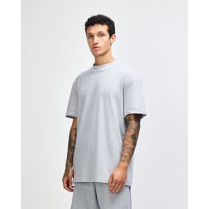 A grey unisex pique mockneck T-shirt with short sleeves, featuring a side view of the model wearing it.