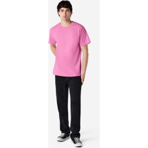 A pink Gildan Ultra Cotton adult T-shirt displayed on a model wearing black pants and shoes, featuring a logo.