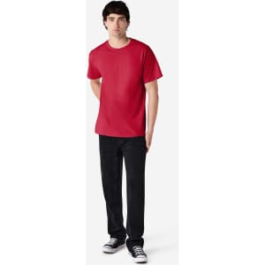 A red Gildan Ultra Cotton adult T-shirt displayed on a model wearing black jeans and sneakers. It features a logo.
