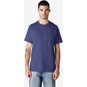 A man wearing a purple Gildan Ultra Cotton adult t-shirt and light blue jeans, standing against a plain background.