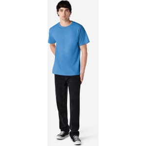 A adult t-shirt in light blue worn by a person, accompanied by black pants and sneakers. The shirt features a logo.