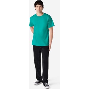 A model in a turquoise Gildan Ultra Cotton adult T-shirt, paired with black jeans and sneakers.