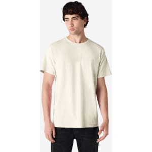 A light cream Gildan Ultra Cotton adult T-shirt on a model, featuring short sleeves and a round neckline.