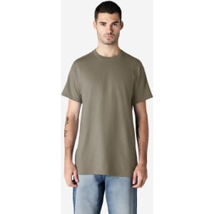 A man is wearing a khaki Gildan Ultra Cotton adult T-shirt, paired with light blue jeans. The shirt has a logo.
