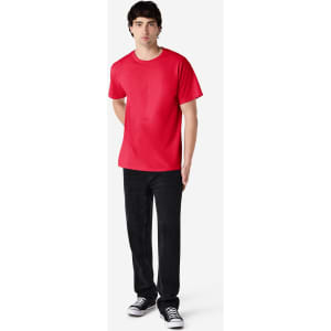 A red Gildan Ultra Cotton adult T-shirt displayed on a model wearing black pants and sneakers. The shirt has a logo.