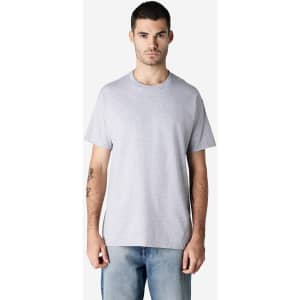 A grey Gildan Ultra Cotton adult T-shirt displayed by a model wearing blue jeans, featuring a plain design and a logo.