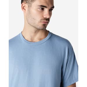 A man wearing a light blue Gildan Ultra Cotton adult T-shirt, featuring a round neckline and short sleeves.
