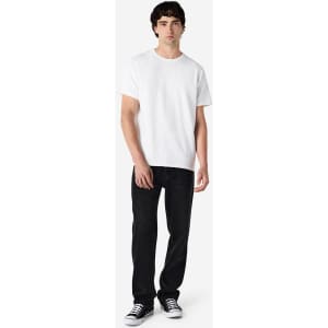 A model wearing a white Gildan Ultra Cotton adult T-shirt paired with black jeans and black sneakers.