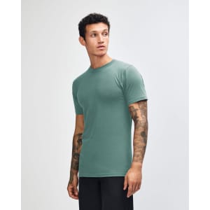 A unisex short sleeve T-shirt in teal, featuring a logo on the front, displayed from the side.