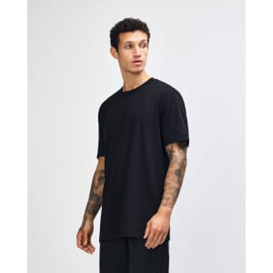 A black unisex short sleeve t-shirt displayed on a model with curly hair, set against a plain background.