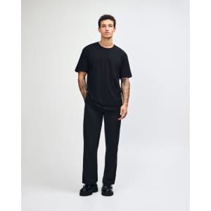 A black unisex fine jersey short sleeve t-shirt displayed on a model, featuring a simple design and relaxed fit.