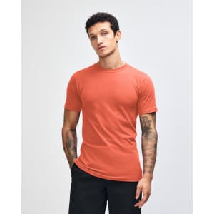 An orange unisex short sleeve t-shirt displayed on a model with long hair, featuring a logo.