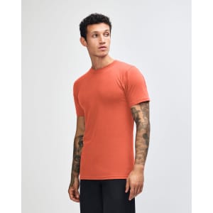 A side view of an orange unisex short sleeve t-shirt with a logo on it.