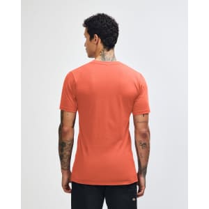 A unisex short sleeve t-shirt in coral with a plain back view, featuring a logo on the neck.
