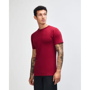 A maroon unisex short sleeve t-shirt displayed on a model, featuring a logo.