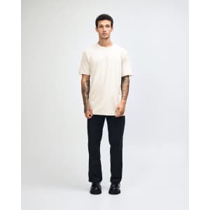 A unisex fine jersey short sleeve t-shirt in a light yellow colour, worn by a model. It has a logo.