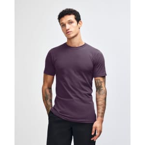 A purple unisex short sleeve t-shirt displayed on a model with straight, long hair. The shirt has a logo.