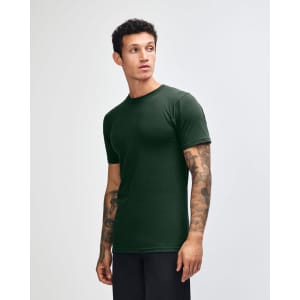 An unisex fine jersey short sleeve t-shirt in dark green, displayed on a model from the side.