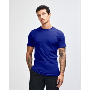 A blue unisex short sleeve t-shirt displayed on a model with curly hair. Features a logo on the shirt.