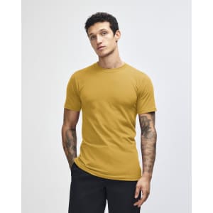 A unisex fine jersey short sleeve t-shirt in mustard yellow, displayed on a model with long hair.