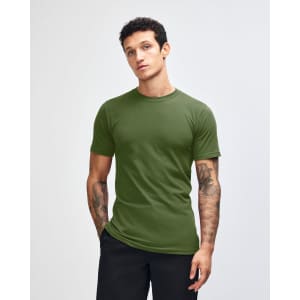 A unisex fine jersey short sleeve t-shirt in a rich green colour, displayed on a model with hands in pockets.