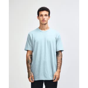 A light blue unisex short sleeve t-shirt displayed on a model. The shirt has a logo branding.
