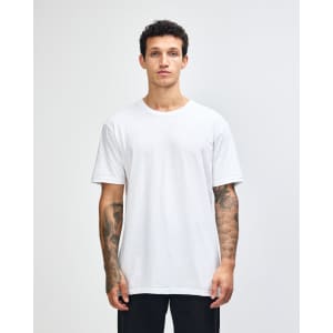 A woman wearing a plain white unisex short sleeve t-shirt. The t-shirt has a logo on it.