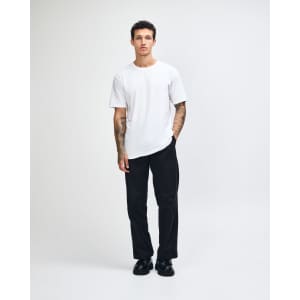 A white unisex short sleeve t-shirt with a fitted design, modelled by a person. Features a branding logo.
