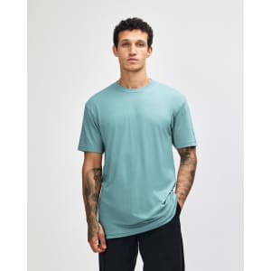 A unisex CVC short sleeve T-shirt in teal, featuring a simple design and a logo on the front.