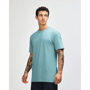 A teal unisex CVC short sleeve t-shirt displayed on a model, featuring a simple design and relaxed fit.