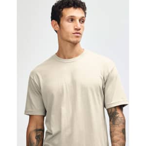 A unisex CVC short sleeve t-shirt in a light beige colour, featuring a simple design and a logo.